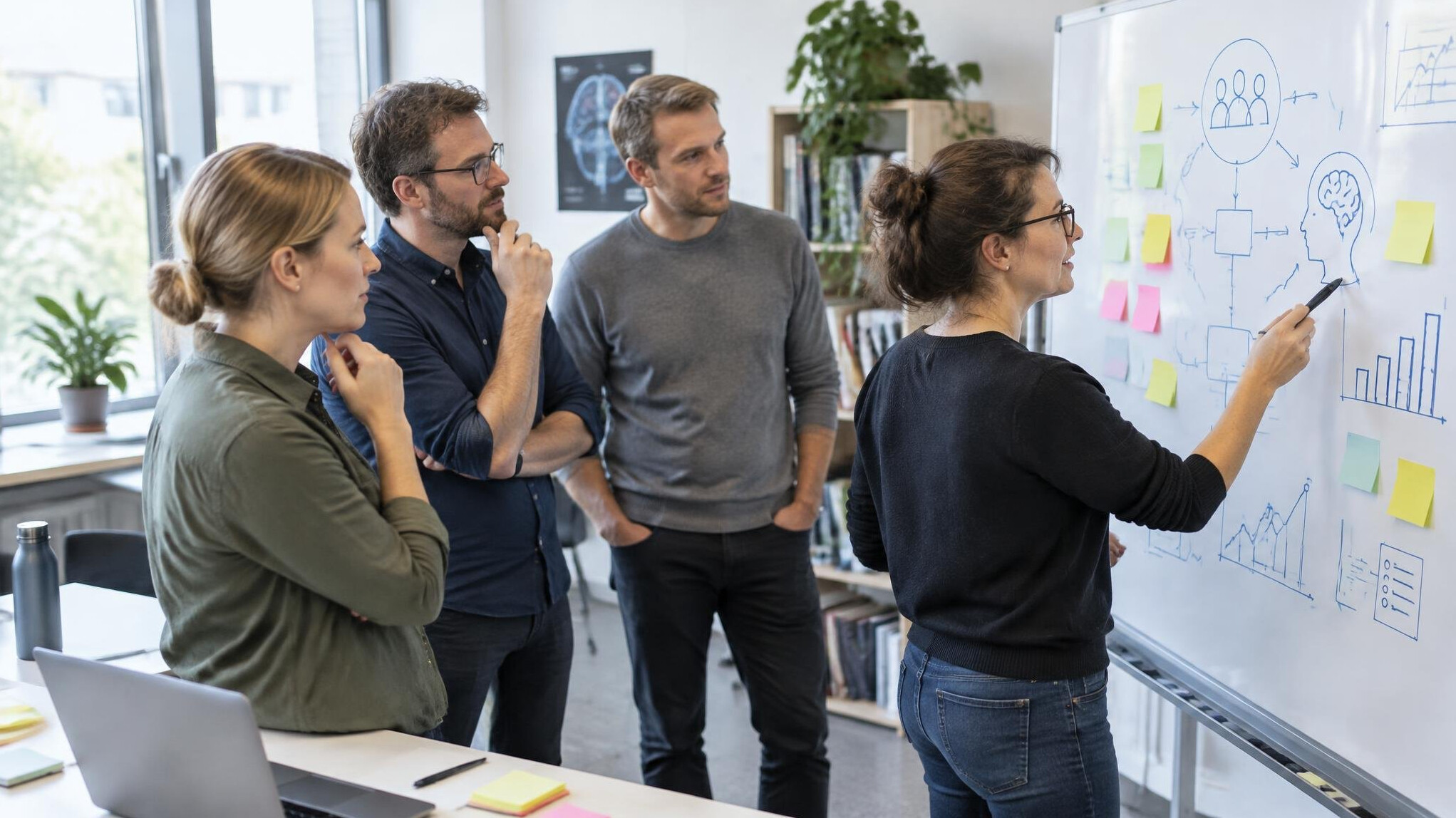 Researchers in a meeting discussing study findings around a whiteboard