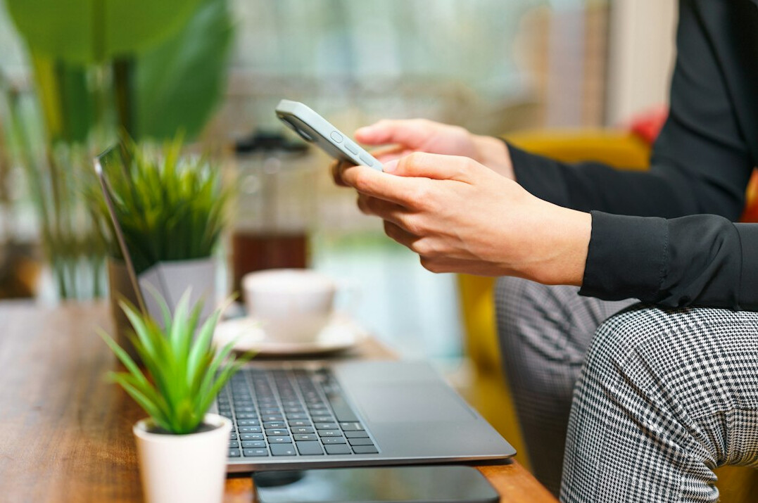 person scrolling smartphone at home